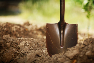 Shovel in soil. Close-up, shallow DOF.