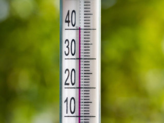 The thermometer in the heat of summer on a natural background.